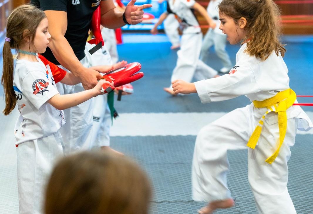 Coach guiding a young athlete during pad training